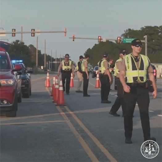 Image of a reentry check point in Kitty Hawk. Dare County Sheriff’s Office deputies stand ready to check for reentry passes along the road.